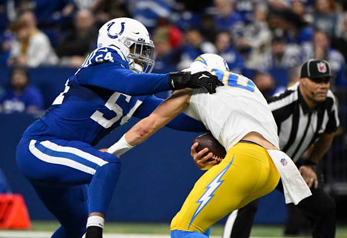 Dec 26, 2022; Indianapolis, Indiana, USA; Los Angeles Chargers quarterback Justin Herbert (10) is sacked by Indianapolis Colts defensive end Dayo Odeyingbo (54) during the second quarter at Lucas Oil Stadium.
